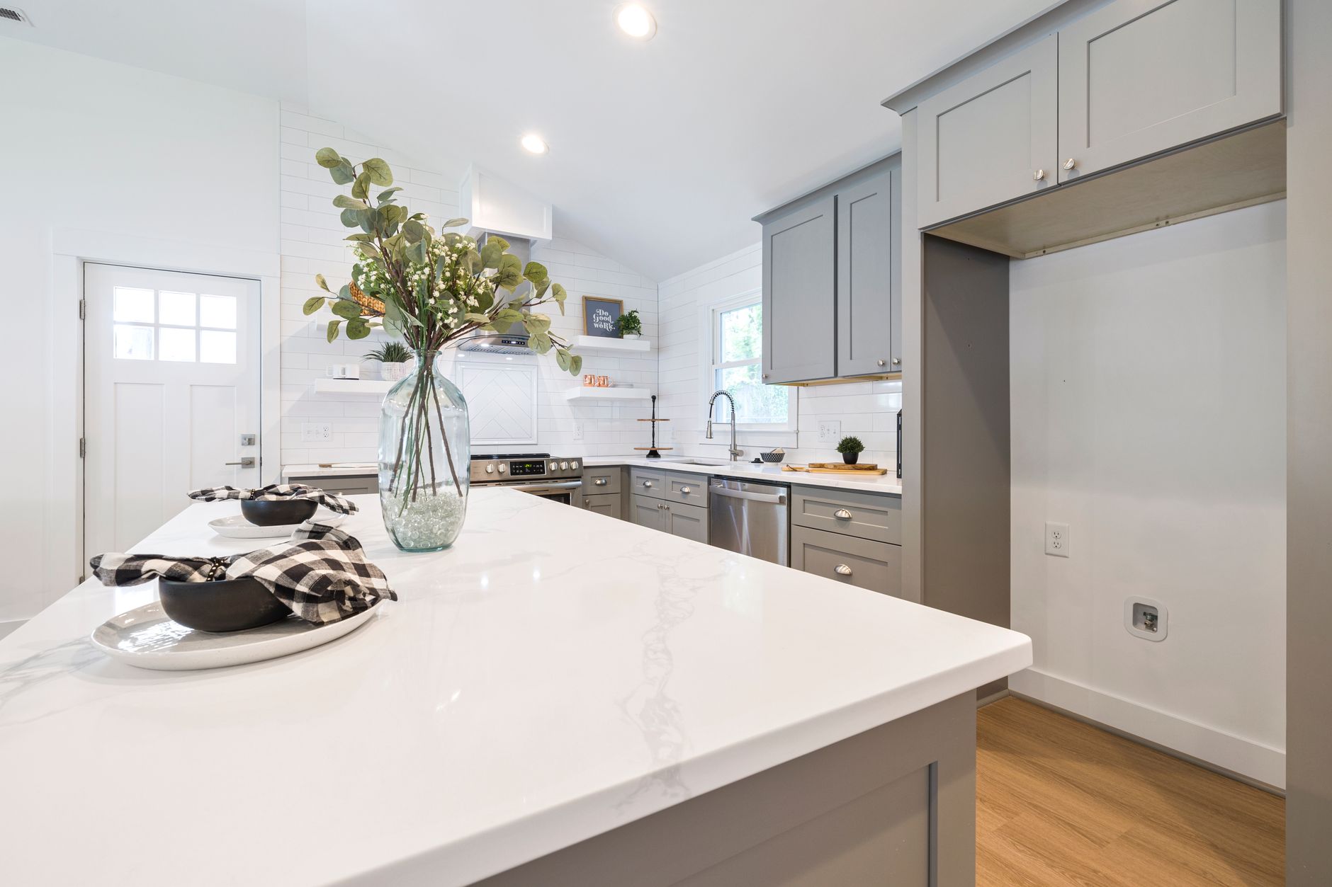 Elegant modern kitchen featuring minimalist cabinets, marble countertop, and decorative vase with eucalyptus in Austin, TX