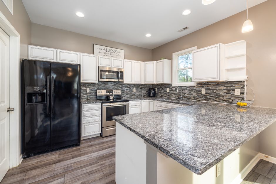 Kitchen with a stone countertop and black appliances.