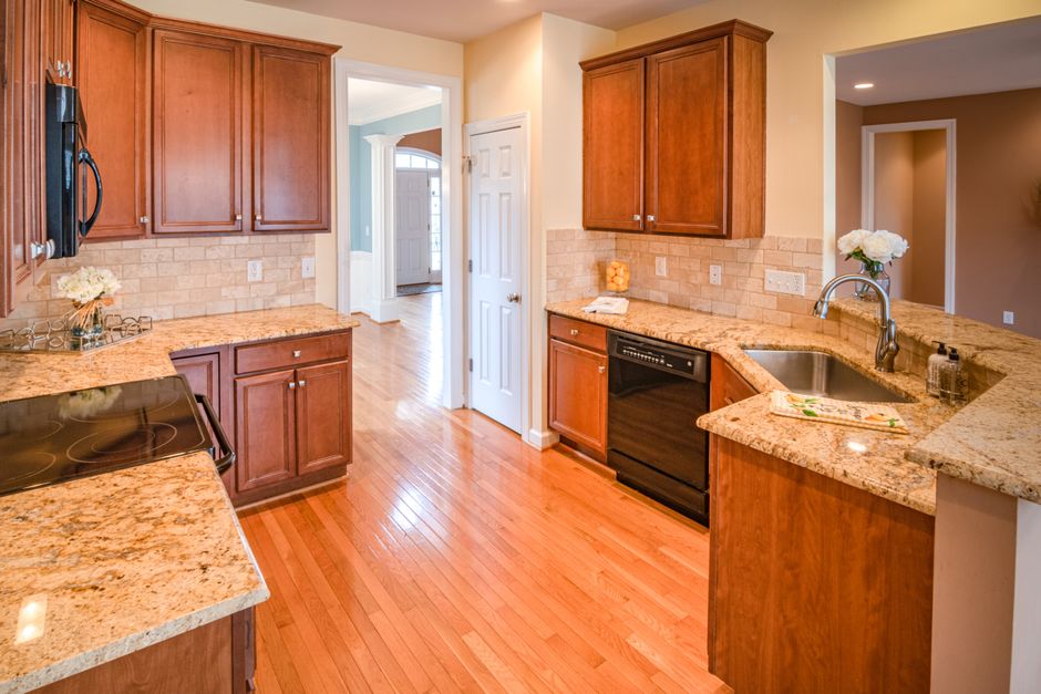 Bright kitchen interior with wooden cabinets and granite countertops.